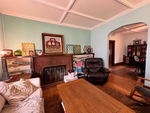 living room featuring a fireplace, crown molding, dark wood-type flooring, and coffered ceiling