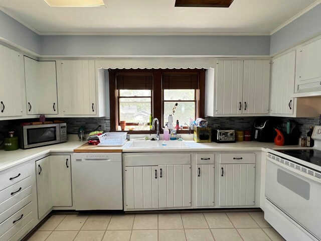 kitchen featuring light tile patterned floors, white appliances, ornamental molding, and sink
