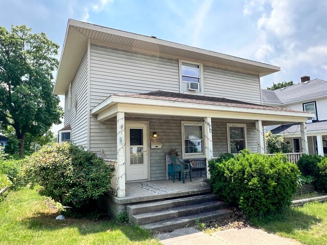 view of front facade with covered porch and cooling unit