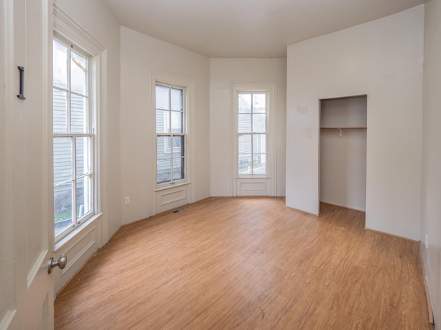 unfurnished bedroom with light hardwood / wood-style floors and a closet