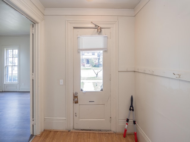 doorway with crown molding and light hardwood / wood-style flooring