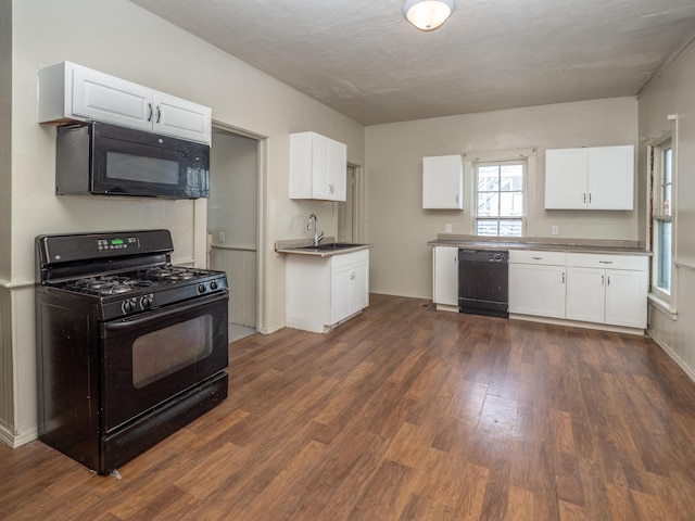 kitchen featuring white cabinets, dark wood-type flooring, and black appliances