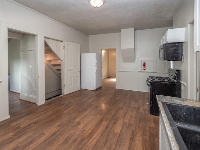 kitchen featuring black stove, dark hardwood / wood-style flooring, white fridge, a textured ceiling, and white cabinets