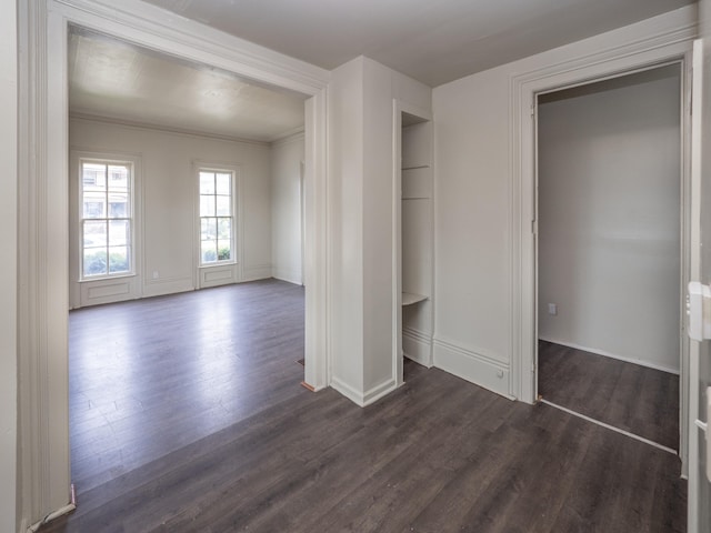 unfurnished bedroom featuring dark hardwood / wood-style flooring, a closet, and crown molding