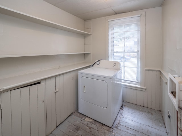 laundry area with wooden walls, washer / clothes dryer, and light hardwood / wood-style flooring