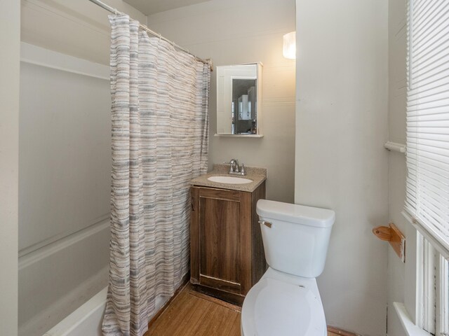 935 W Lovell St, Kalamazoo, MI 49007 - full bath featuring toilet, wood finished floors, vanity, and shower / bath combo with shower curtain