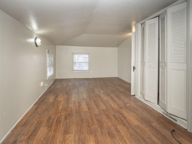 bonus room with dark wood-type flooring and vaulted ceiling