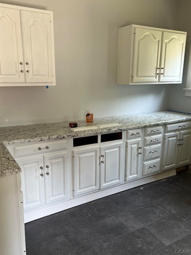 kitchen featuring white cabinets and light stone counters