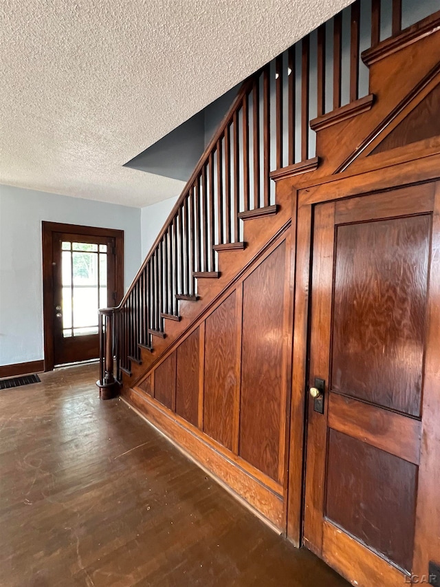 stairway featuring hardwood / wood-style floors and a textured ceiling