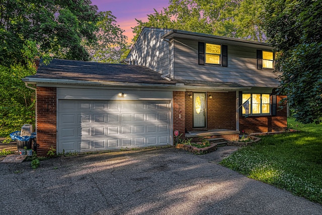 view of front property featuring a garage and a yard