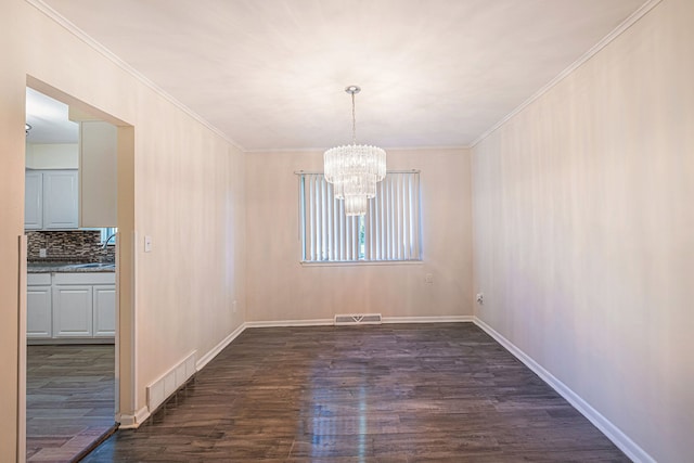 unfurnished dining area with crown molding, sink, dark wood-type flooring, and a notable chandelier