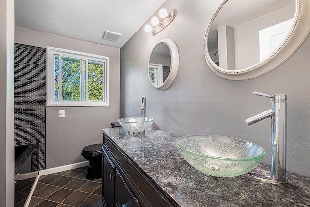 bathroom with tile patterned flooring, vanity, and toilet