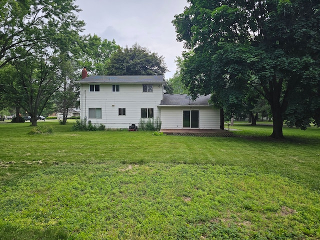 rear view of property featuring a yard and a deck