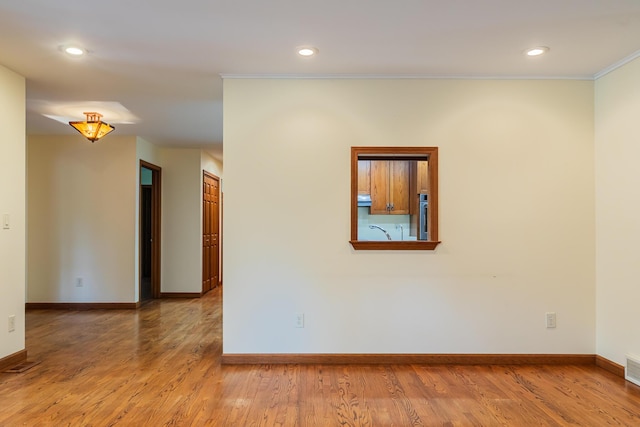 1477 E Hastings Lake Rd, Jonesville, MI 49250 - spare room featuring ornamental molding, baseboards, wood finished floors, recessed lighting, and a sink