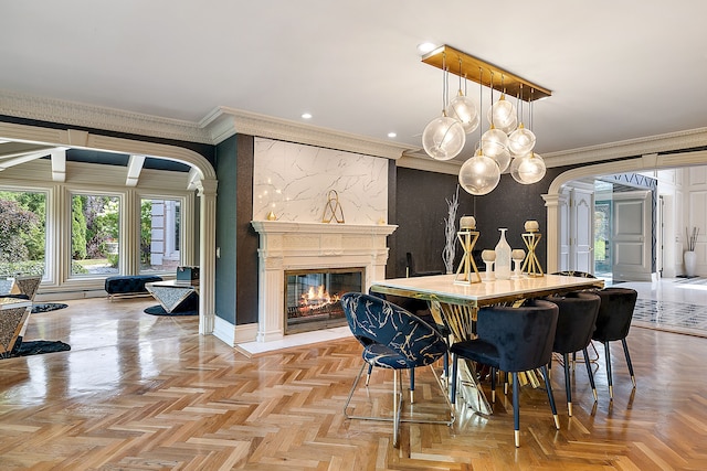 dining room with ornamental molding, a fireplace, and light parquet flooring