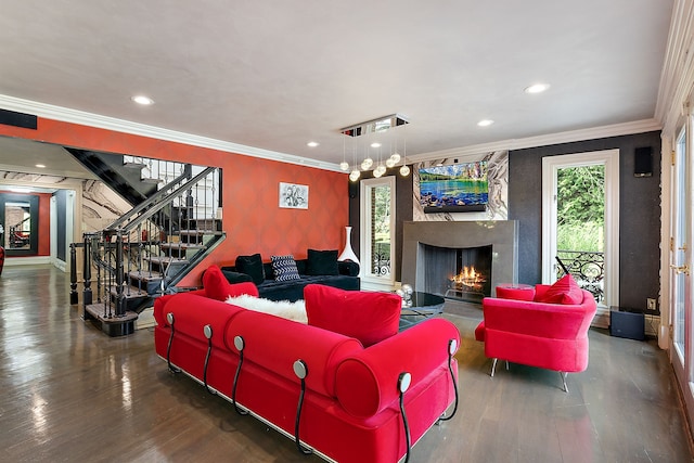 living room featuring wood-type flooring, a fireplace, and ornamental molding