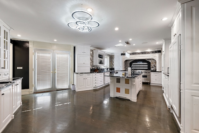 kitchen with a center island, french doors, stainless steel appliances, tasteful backsplash, and white cabinets