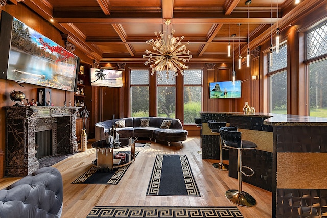 living room featuring wood walls, a fireplace, light hardwood / wood-style floors, and coffered ceiling