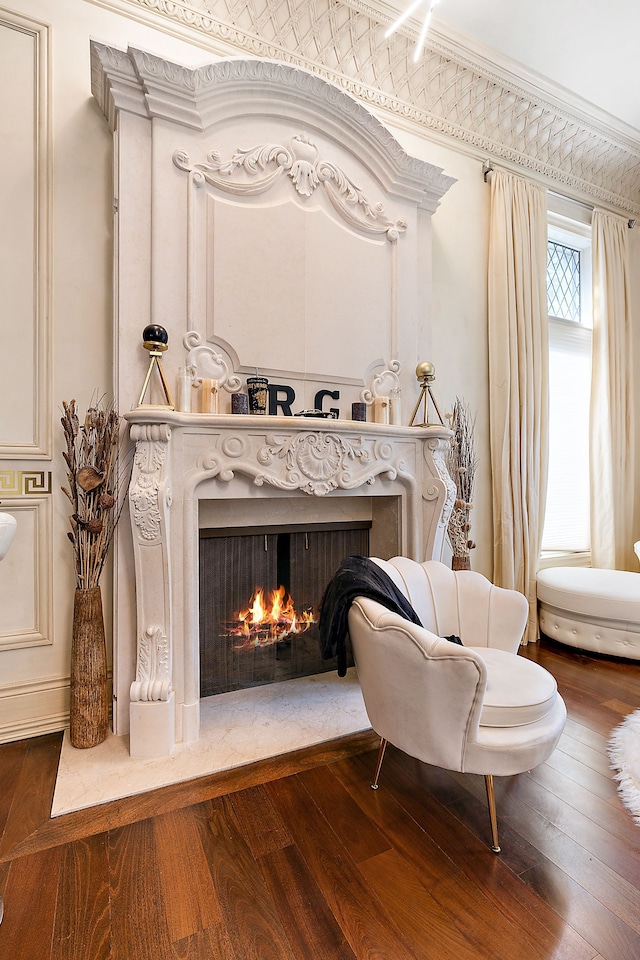 sitting room with crown molding and dark wood-type flooring