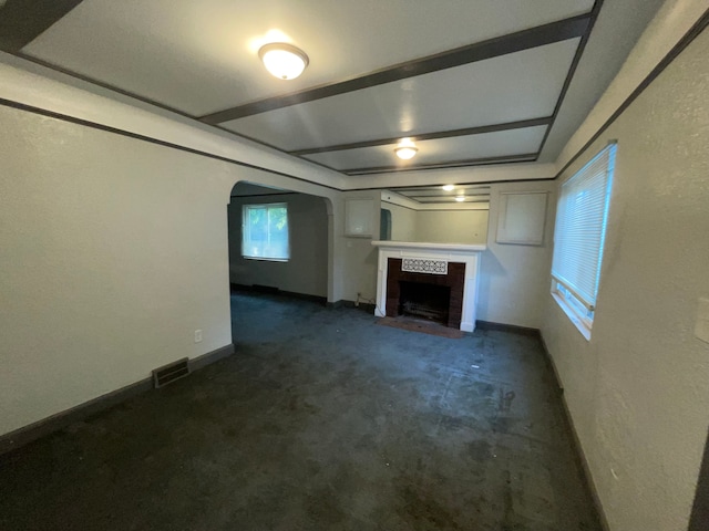 unfurnished living room with dark carpet and a tiled fireplace