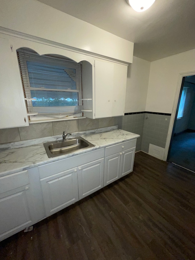 kitchen featuring white cabinets, dark hardwood / wood-style flooring, tile walls, and sink