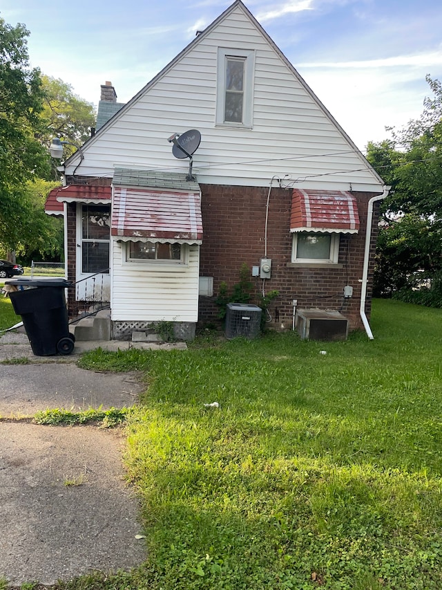 view of property exterior featuring central air condition unit and a lawn