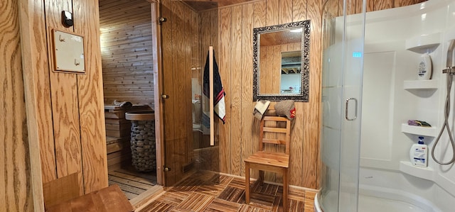 bathroom featuring wood walls and a shower with shower door