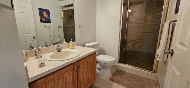 bathroom with tile patterned floors, vanity, a shower with shower door, and toilet