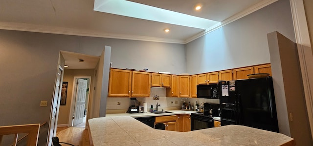 kitchen with black appliances, crown molding, sink, a skylight, and kitchen peninsula