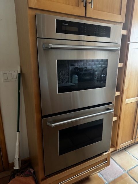 details featuring stainless steel double oven and brown cabinets