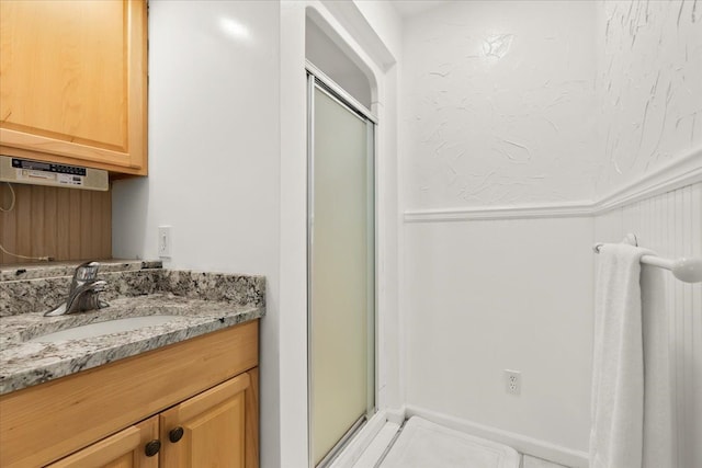 bathroom with vanity and a shower with door