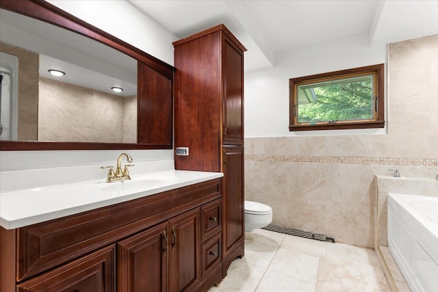 bathroom featuring tile walls, a bathtub, vanity, toilet, and tile patterned floors