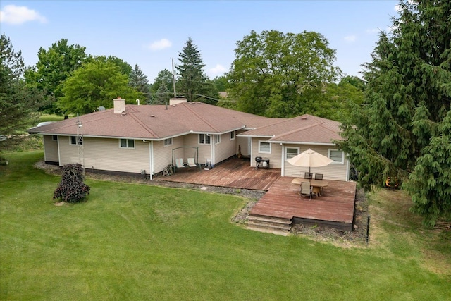 rear view of property featuring a yard and a wooden deck