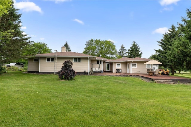 rear view of property with a yard and a deck