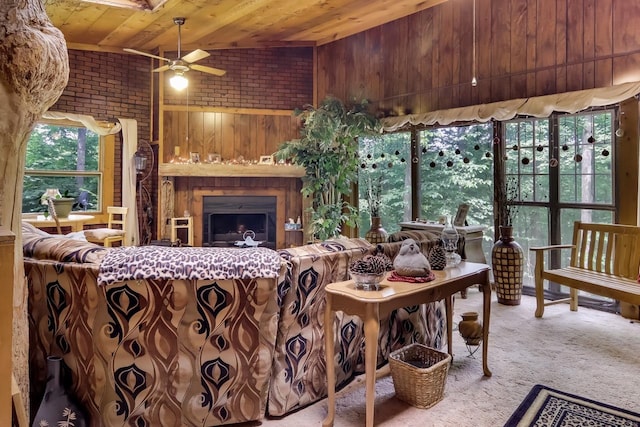 carpeted living room with lofted ceiling, wooden walls, ceiling fan, and wooden ceiling