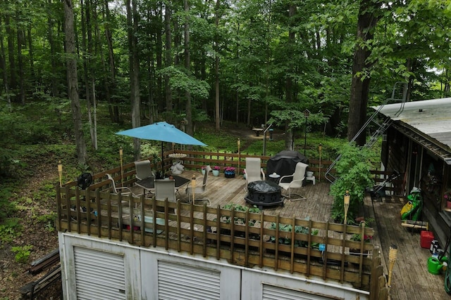 wooden deck featuring grilling area and an outdoor fire pit