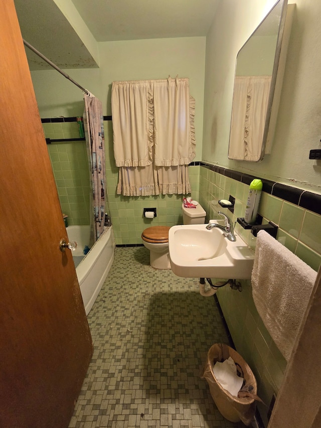 full bathroom with sink, shower / bathtub combination with curtain, tile walls, and toilet