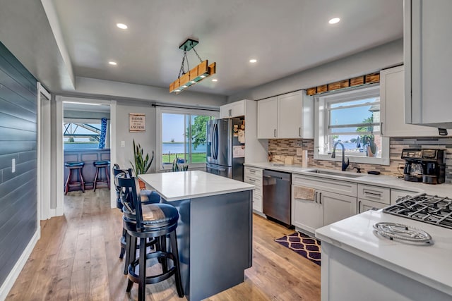 kitchen featuring plenty of natural light, a center island, light hardwood / wood-style floors, and appliances with stainless steel finishes