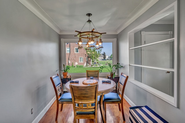 dining space featuring crown molding, hardwood / wood-style floors, and a notable chandelier