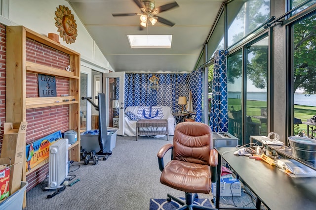 sunroom / solarium featuring ceiling fan and vaulted ceiling with skylight