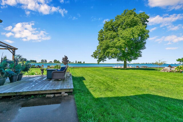 view of yard with a deck with water view