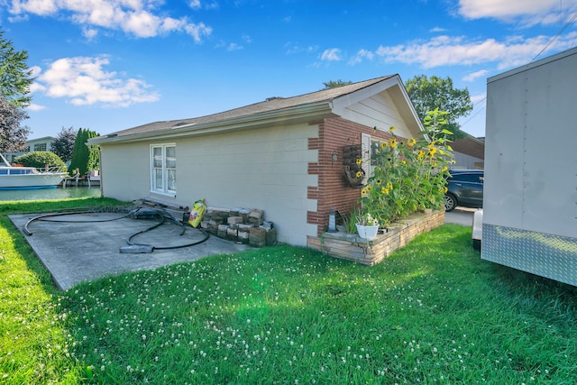 view of side of home with a yard and a patio