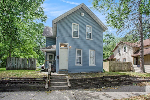 view of front of house featuring a shingled roof and fence