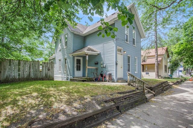 view of front facade featuring a front yard and fence