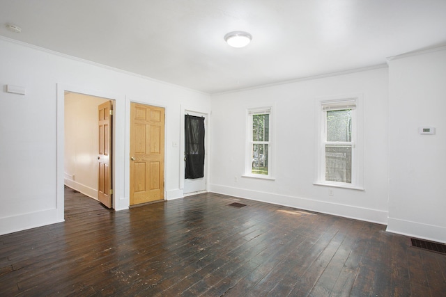 empty room featuring baseboards, dark wood-type flooring, and crown molding