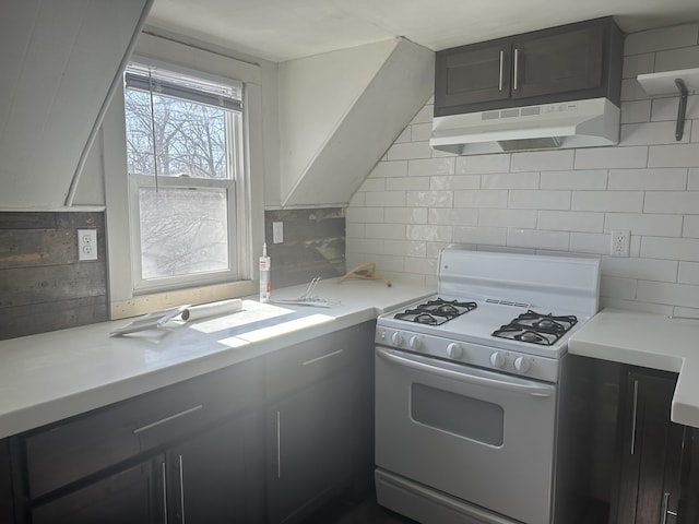 kitchen featuring under cabinet range hood, decorative backsplash, light countertops, and white range with gas stovetop