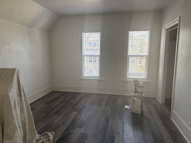 bonus room with baseboards, lofted ceiling, and dark wood-style flooring