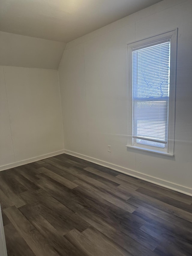 bonus room featuring baseboards, lofted ceiling, and dark wood finished floors