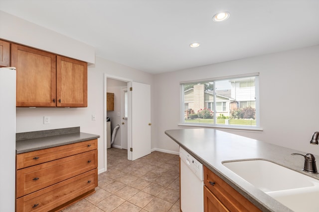 kitchen featuring light tile patterned flooring, independent washer and dryer, white appliances, and sink