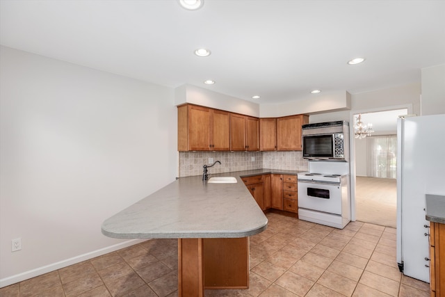 kitchen with white appliances, sink, decorative backsplash, kitchen peninsula, and a breakfast bar area